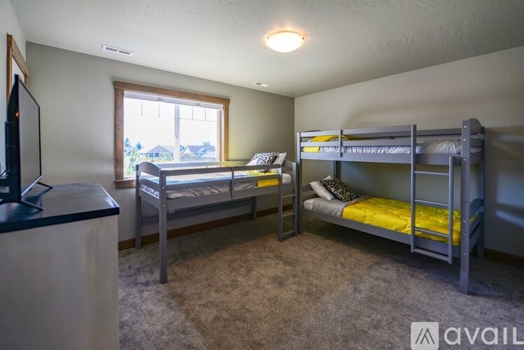 A bedroom with two bunk beds and a television.