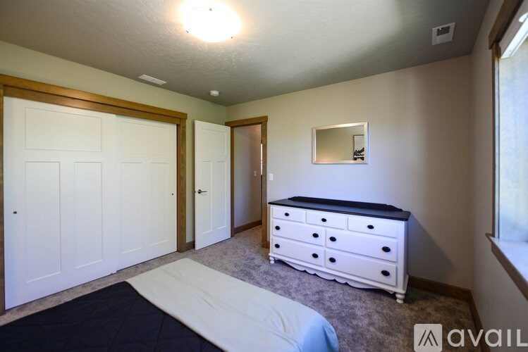 A bedroom with a bed, dresser, and mirror.