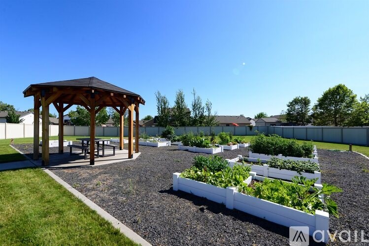 A garden with a pavilion and raised beds of vegetables.