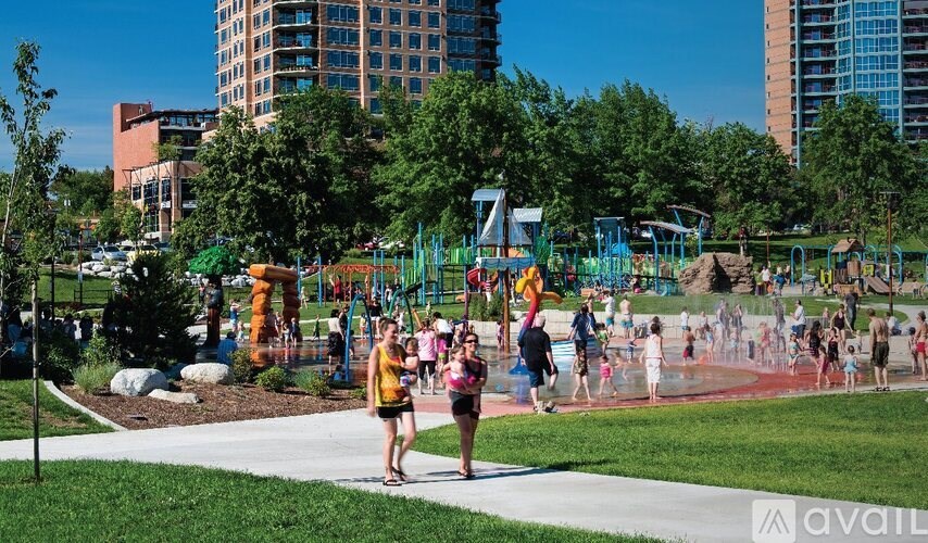 A park with people walking and playing in the playground.