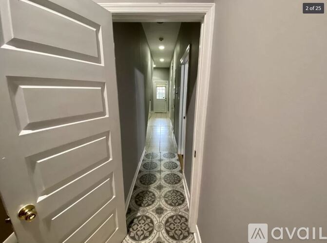 A hallway with a tiled floor and white walls.