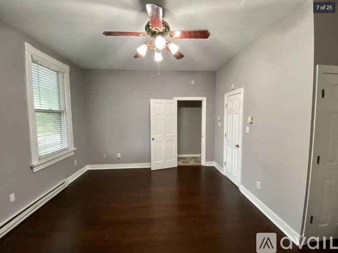 A room with a ceiling fan and wooden flooring.