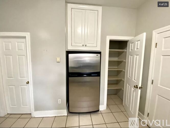 A kitchen with a fridge and a cabinet above it.