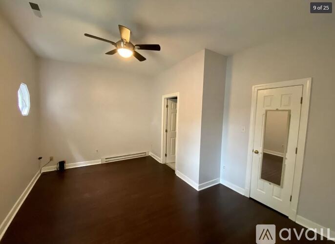 A room with a ceiling fan and two doors.