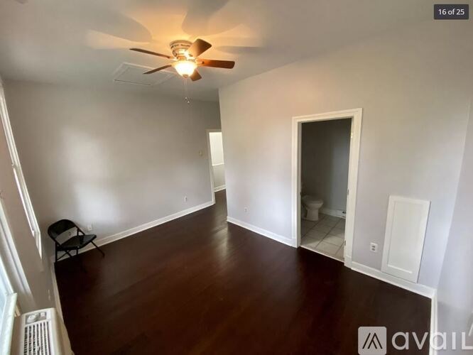 A room with a ceiling fan and a chair.