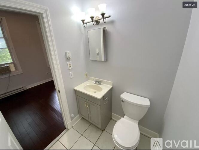 A white toilet sits next to a sink in a small bathroom.