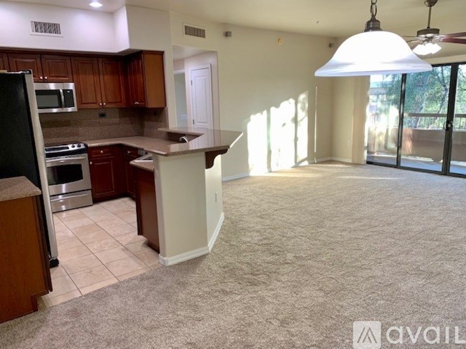 A kitchen with a refrigerator, oven, and microwave.