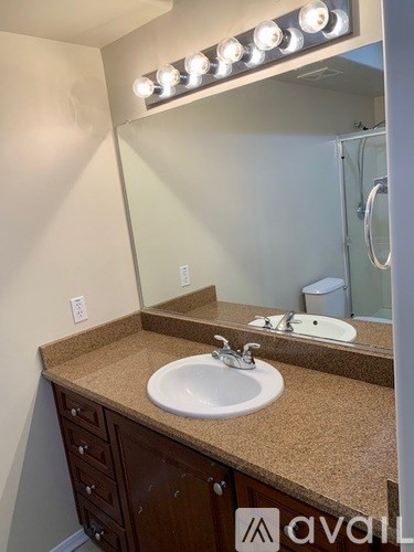 A bathroom with a sink, mirror, and lights above it.