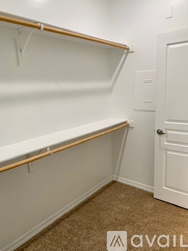 A white wall with a door and a shelf.