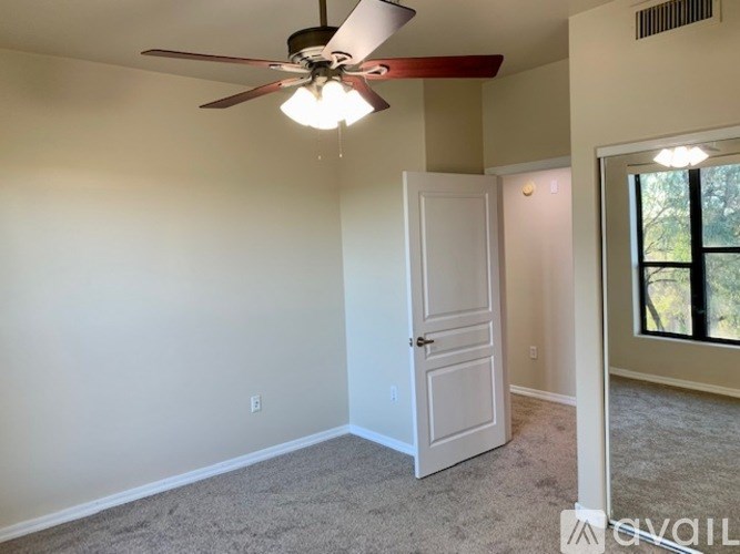 A room with a ceiling fan and a door.