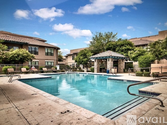 A swimming pool surrounded by a patio and a pavilion.