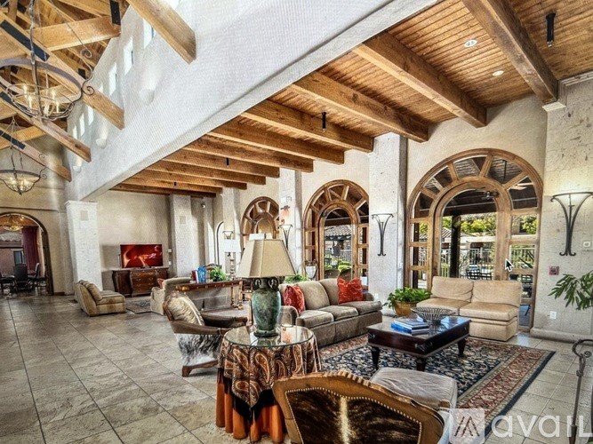 A living room with a wooden ceiling and a variety of furniture.