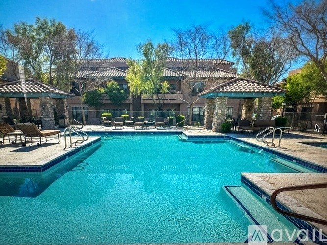 A large swimming pool in front of a house with a tiled roof.