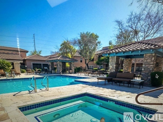 A pool with a blue tiled edge and a brown sofa.