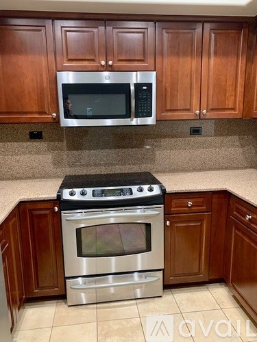 A kitchen with a stove and microwave above it.