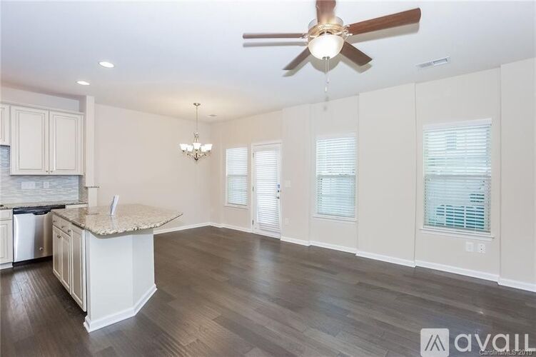 A spacious kitchen with a fan and a chandelier.