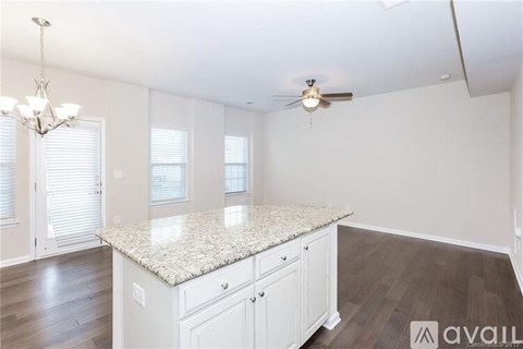 A kitchen with white cabinets and a granite countertop.