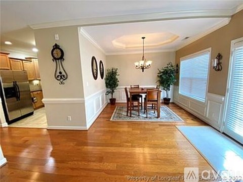 A dining room with a wooden table and chairs.