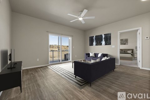 A spacious living room with a dark sofa and a television.