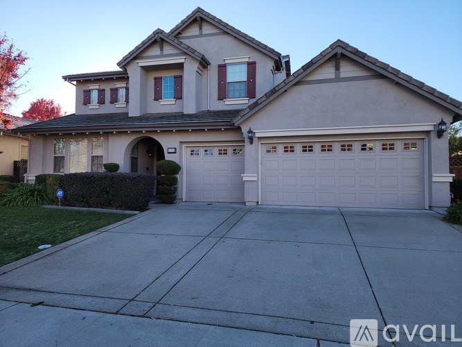 A two-story house with a garage and a driveway.