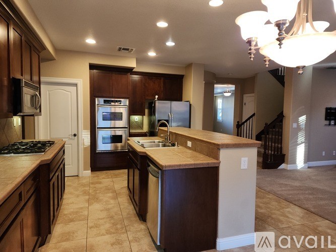 A kitchen with brown cabinets and a wooden island.