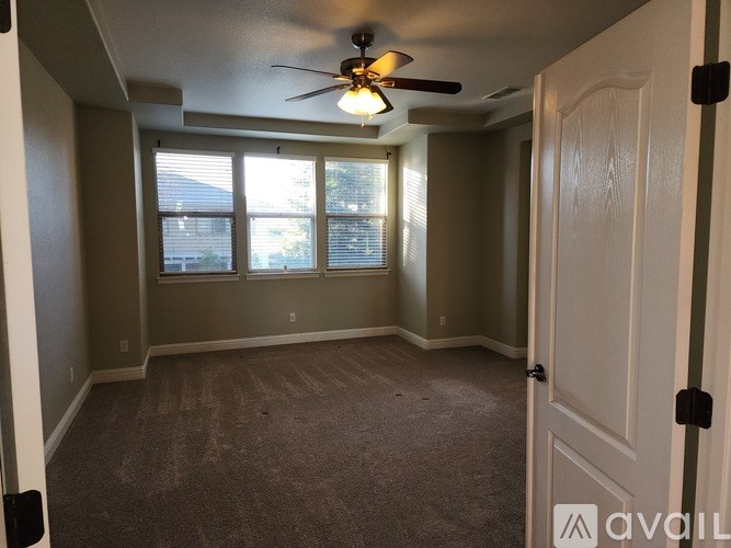 A room with a ceiling fan and a door.