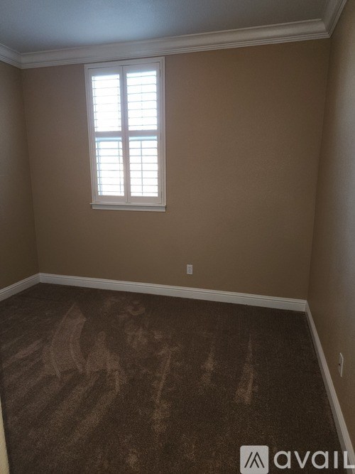 A room with a window and carpeted floor.