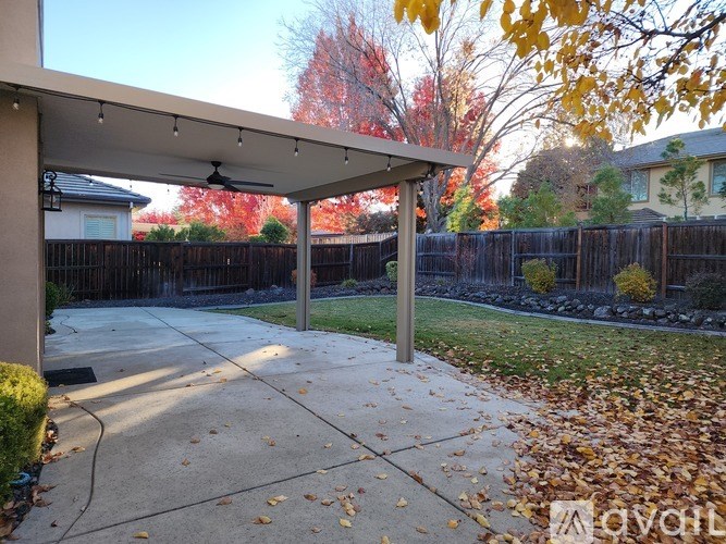 A covered patio area with a white roof and a concrete floor.