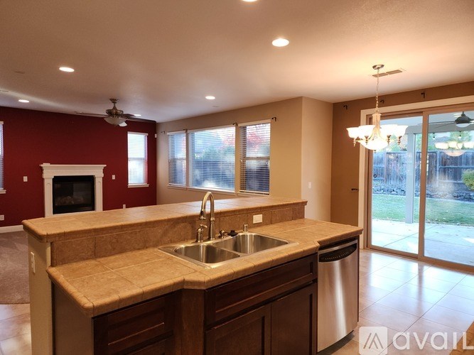A kitchen with a red wall and a sink.