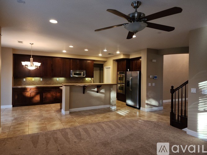 A modern kitchen with a ceiling fan and recessed lighting.