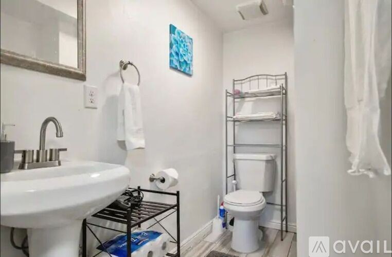 A bathroom with a white sink, toilet, and a bunk bed.