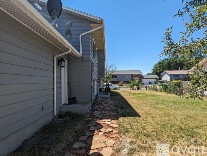 A house with a satellite dish on the roof and a stone pathway leading to the door.