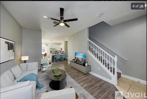 A living room with a white couch and a ceiling fan.