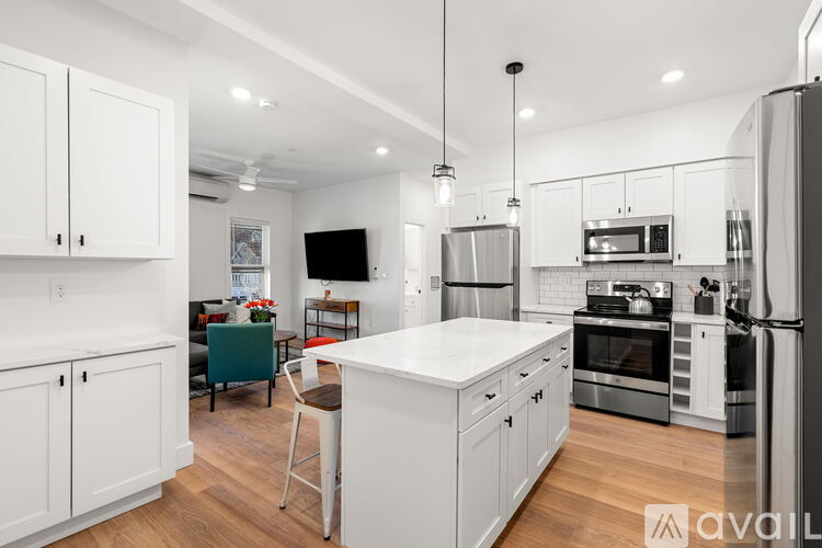 A modern kitchen with white cabinets and stainless steel appliances.