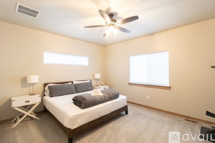 A bedroom with a bed, nightstand, and window.