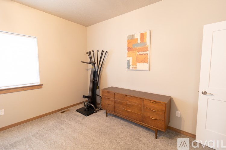 A room with a wooden dresser and a painting on the wall.