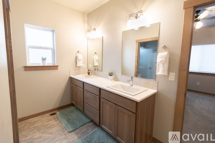 A bathroom with a vanity, mirror, and a window.