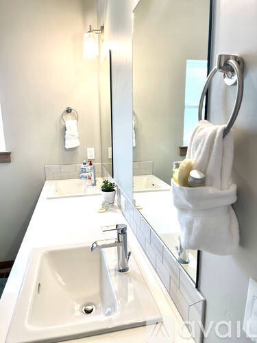 A white sink in a bathroom with a mirror above it.