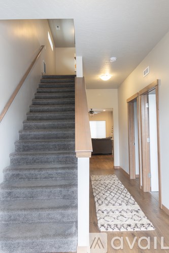 A staircase with a carpeted runner and a wooden handrail.