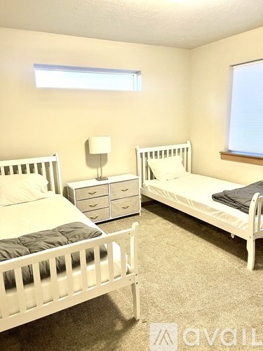 A bedroom with two beds and a dresser.