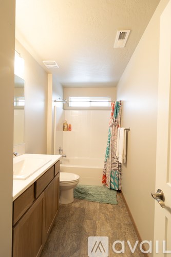 A bathroom with a toilet, sink, and shower.