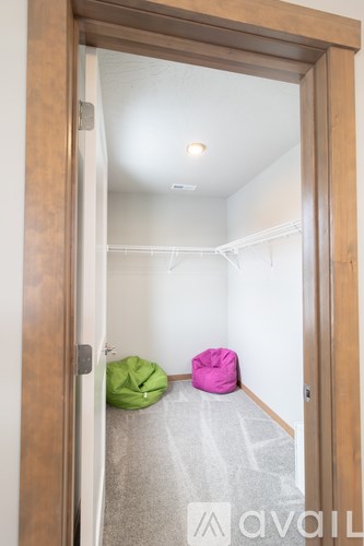 A room with a pink bean bag and a green bean bag in it.