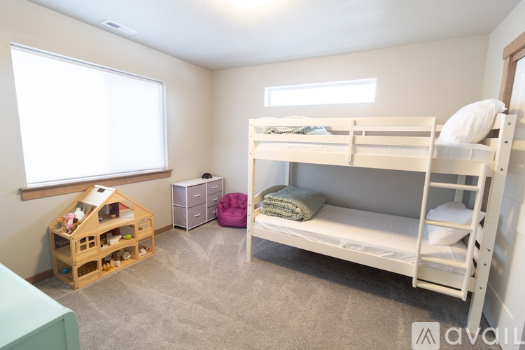 A bedroom with two bunk beds and a toy house.