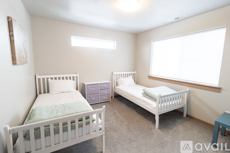 A bedroom with two twin beds and a nightstand.