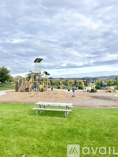 A playground with a swing set and a picnic table.