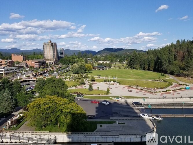 A view of a campus with a parking lot and a body of water.