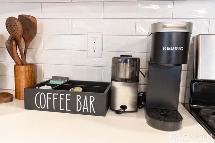 A coffee bar with a Keurig machine and a coffee grinder.