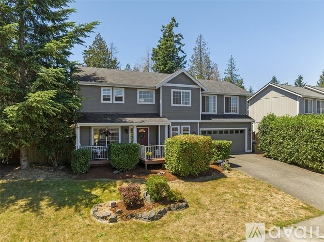 A house with a well-maintained lawn and a clear sky in the background.