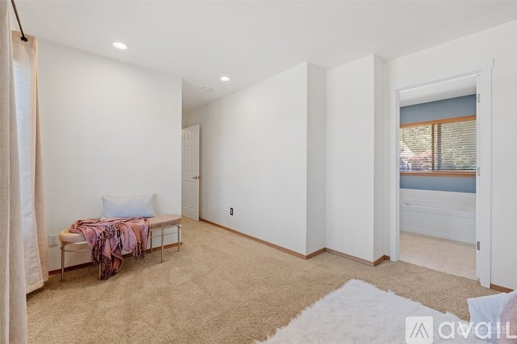 A bedroom with a bed and a window with blinds.
