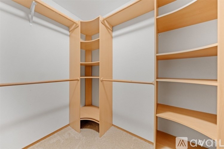 A wooden shelving unit with a central door and shelves on either side.